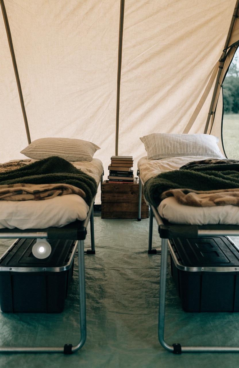 Cabin tent interior with cots, books and storage bins