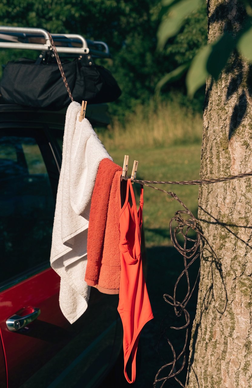 Clothesline from a car roof rack to a tree with towels drying