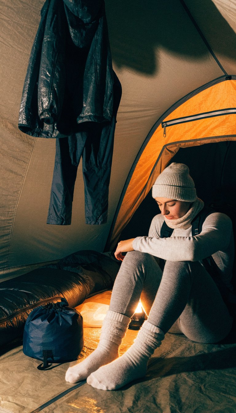 Person in dry merino sleep layers inside a winter tent